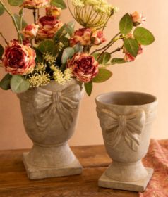 SET OF TWO CONCRETE URNS WITH BOW DETAIL