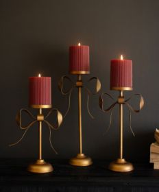 SET OF THREE ANTIQUE BRASS PILLAR CANDLE STANDS -BOW DETAIL